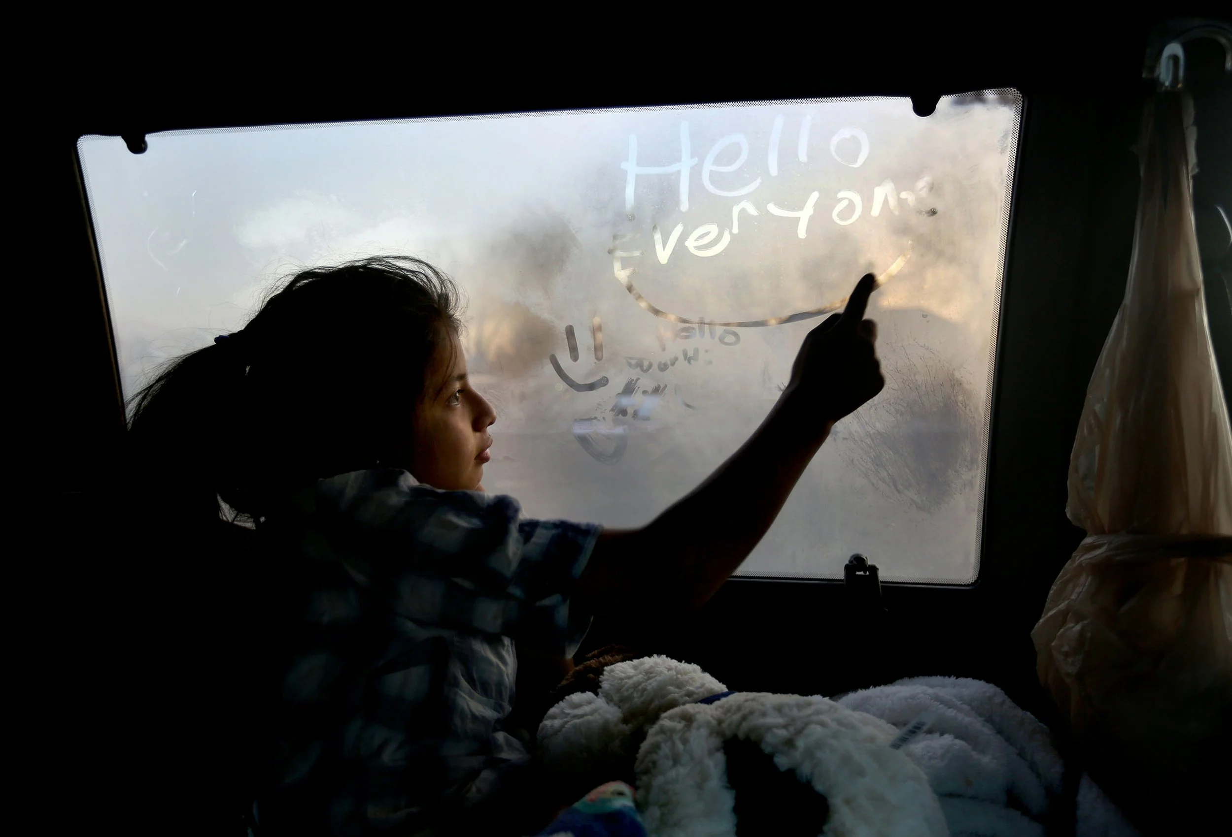  Elvia Hernandez Chile, 11, writes on the steamed window of a van that she and her family are living out of on a frigid morning in South Salt Lake on Tuesday, Dec. 26, 2017. The van's heater is broken. 