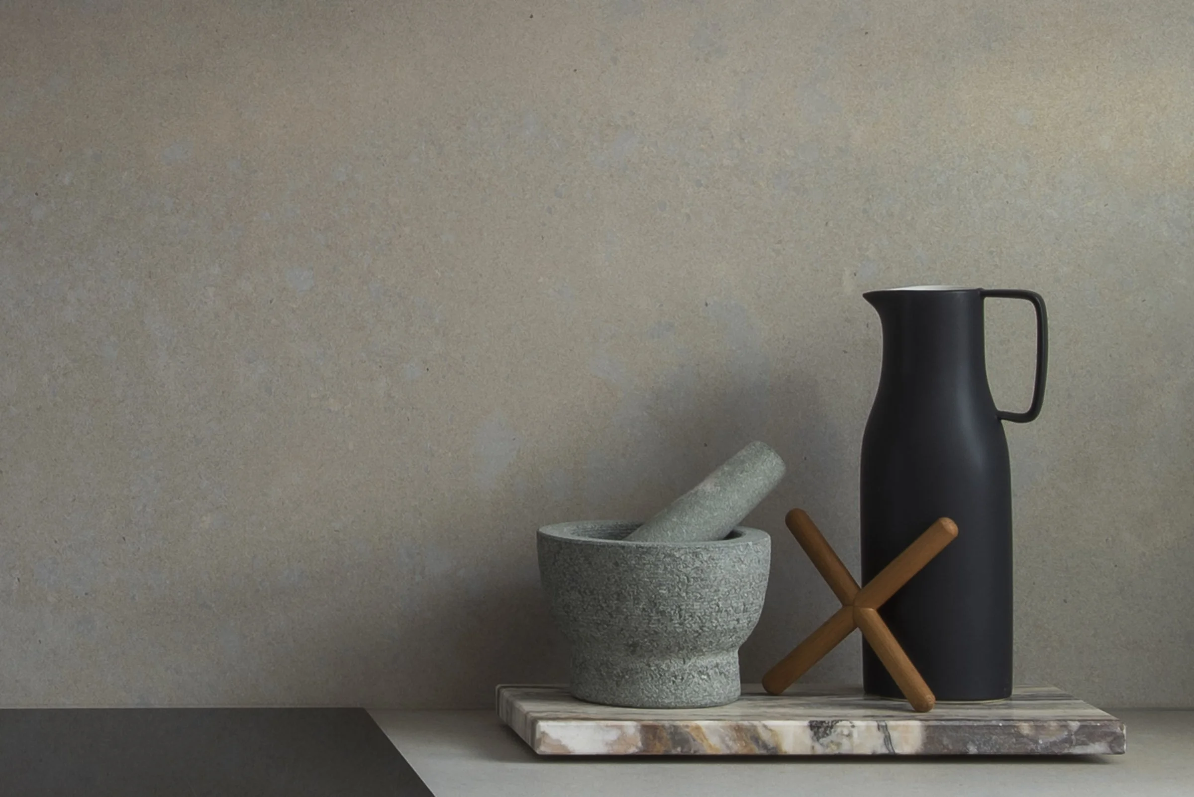 product photography and interior photography of kitchen items sitting on a countertop surface including a mortar and pestle, and a black jug