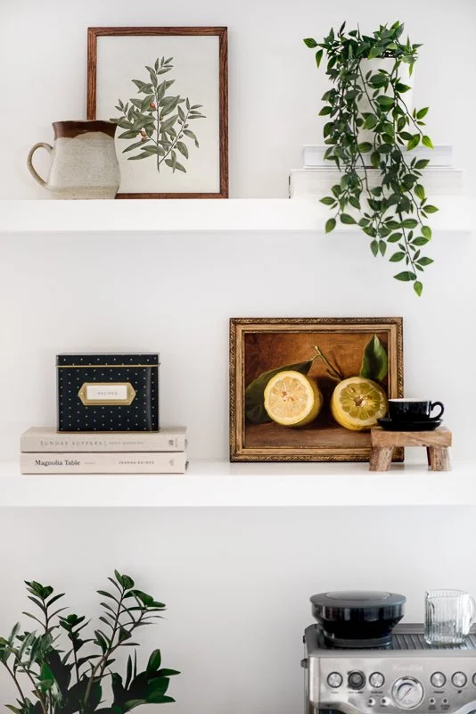 Product photography of shelving styled with fine art prints and home decor
