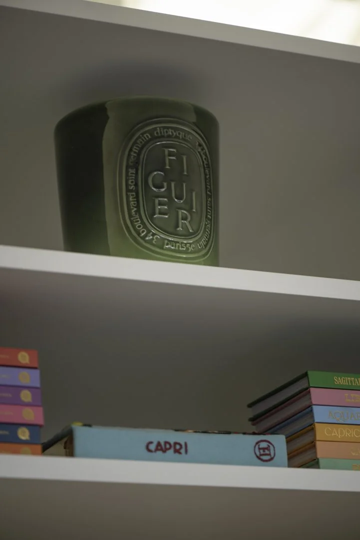 product photography of a figuier candle styled on a shelf in a luxury closet