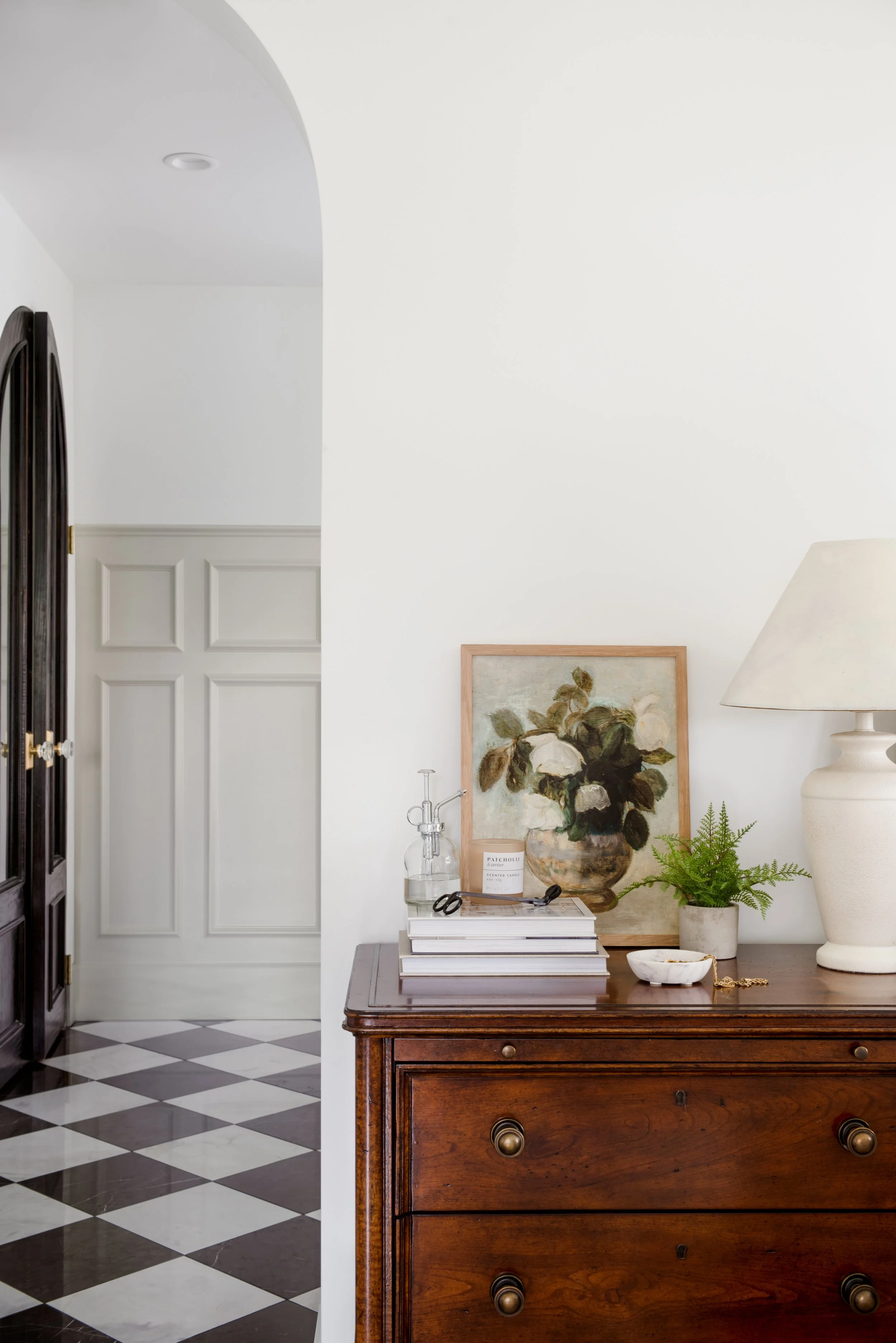 Product photography and interior photography of a nightstand styled with a fine art print, books and a cream lamp