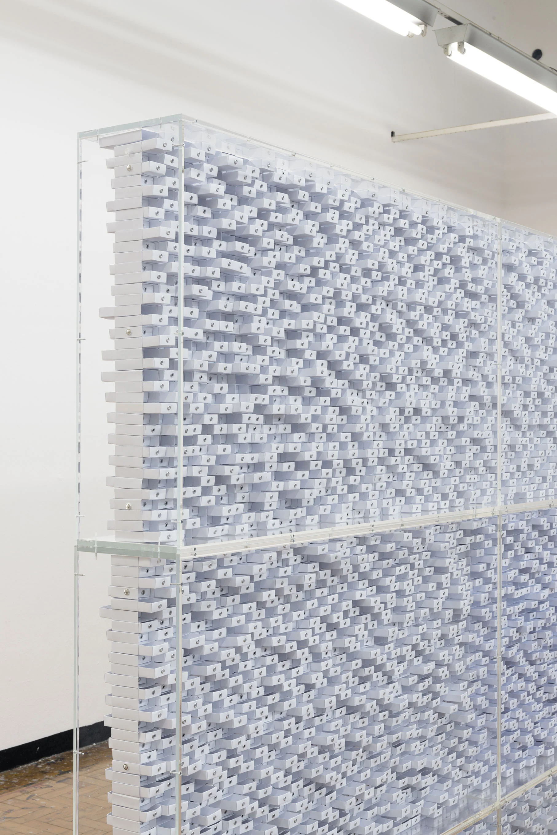   Funes , 2013&nbsp;[detalhe] 13.572 caixinhas em papelão branco, 12 módulos em acrílico,&nbsp;27.144 ilhoses, 480 parafusos, 240 imãs, 48 tarugos. 210 x 494 x 22 cm  Foto: Edouard Fraipont 