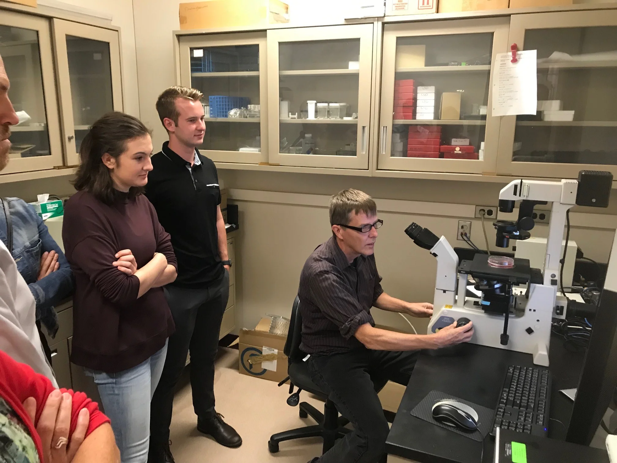 Dr. Tim Starr demonstrated how cancer cells are identified through a high powered microscope in his lab.