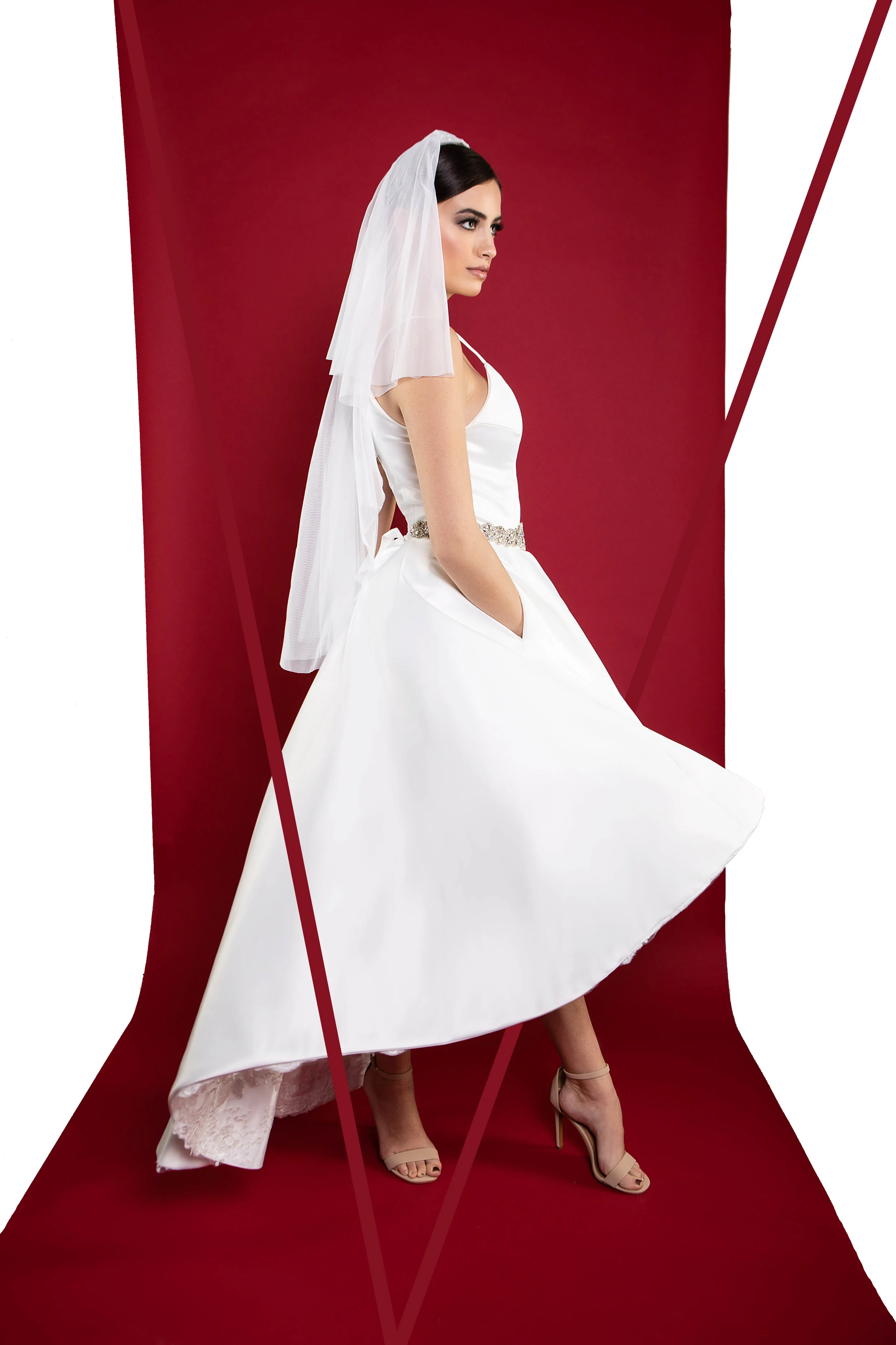 Style: Calla Lily Hi-Lo cocktail style wedding gown. Luxurious satin twill in pearl white. Hand sewn lace applique detail design inside-around hemline to leave the exterior shell clean and chic, but not forsaking detail. The foundation has layers of tulle and netting to give the gown elevation with no needed of a petticoat. Bodice has boning in front and back. The bias cut straps and deep pockets gives this gown all the flare. (Belt sash not included.) Pictured with a custom fingertip length drop veil. Custom listing starting @ $5,200