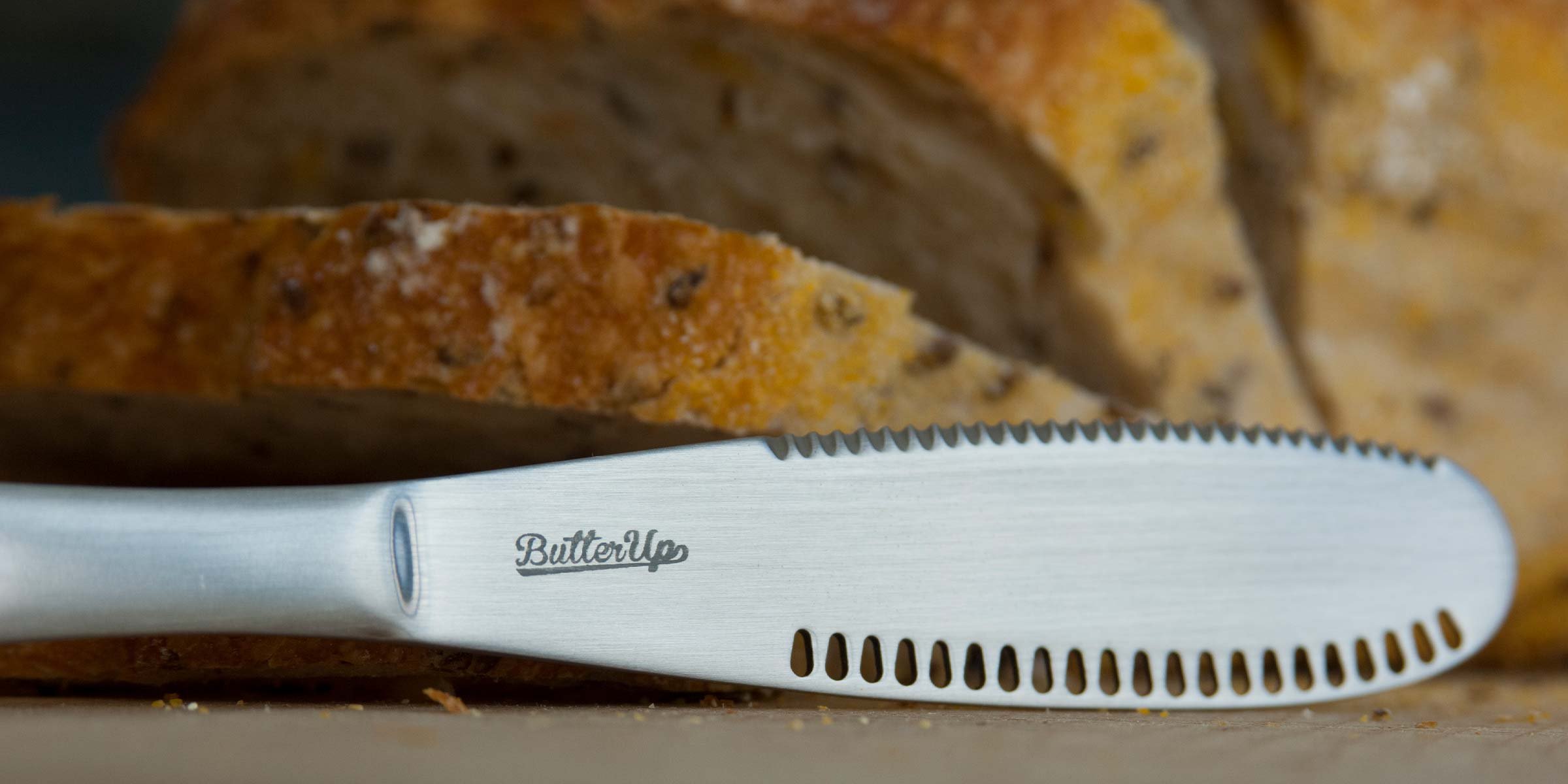 Detailed side view of Butter Up knife with sliced bread in background