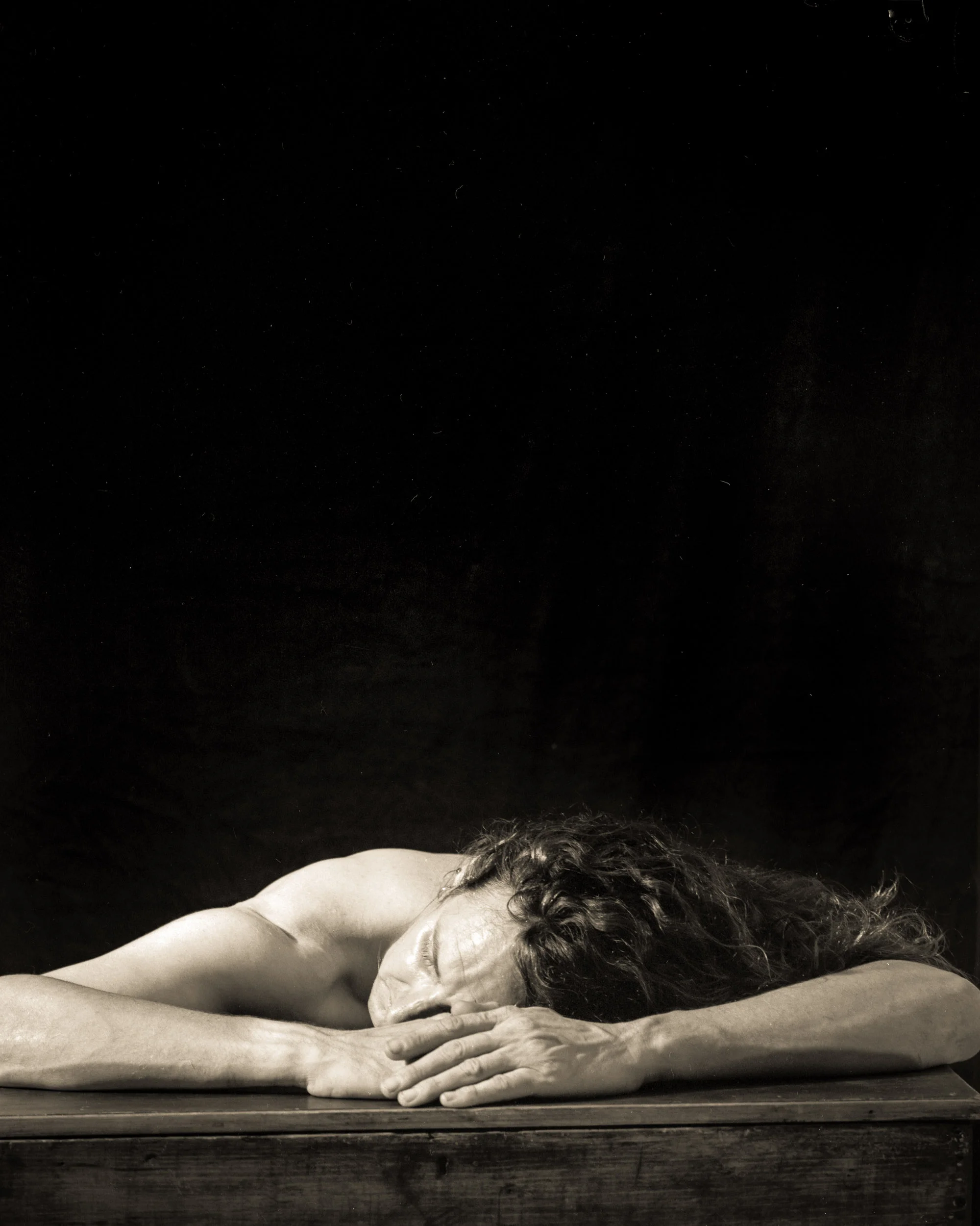 Self portrait for TAFE while I was completing my Diploma in Digital Imaging, circa 2006 taken with large format camera on some film, printed in the darkroom. My knee is on the cable release.