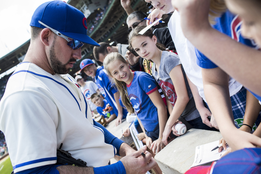 Infielder Mike Olt signs autographs before the game.