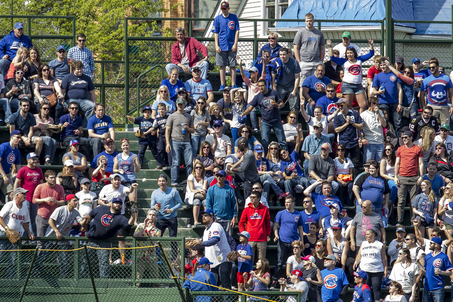 A fan tries to catch a ball thrown into the bleachers. 