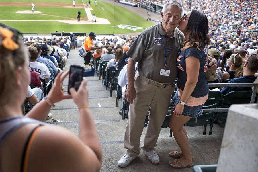 Drayonah Garza gives usher Bill Fundero a kiss on the cheek. Fundero has worked for the Tigers in some capacity since 1968. 
