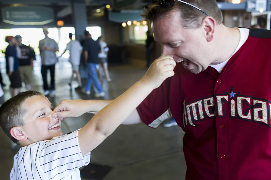 Mike Zimmerman and his 9-year-old son Mike pinch each other's nose before the game.