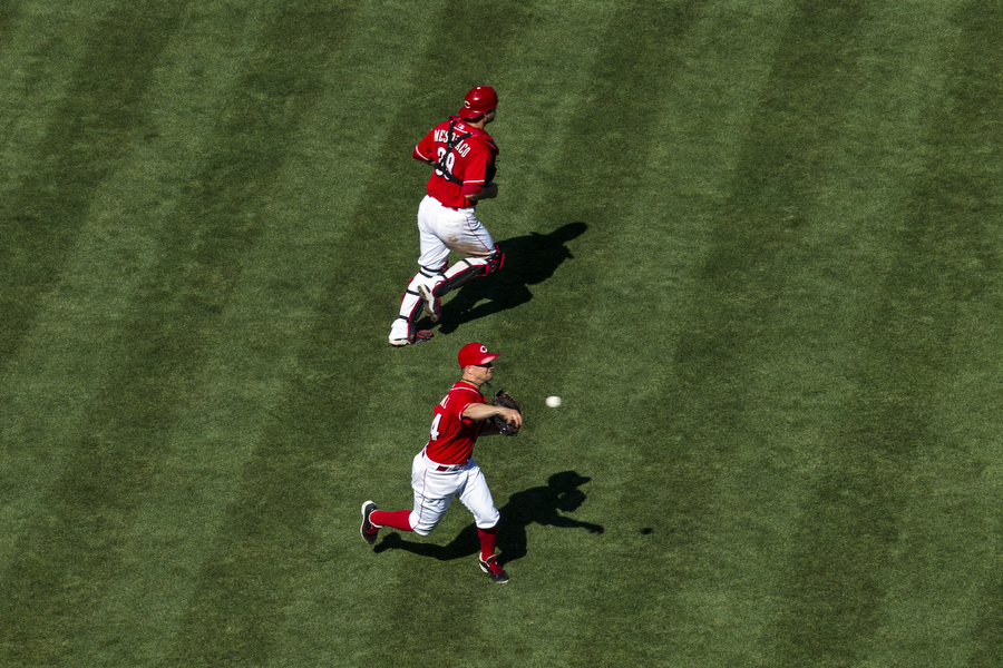 Reds pitcher Mike Leake throws to first on a weakly hit ground ball. 