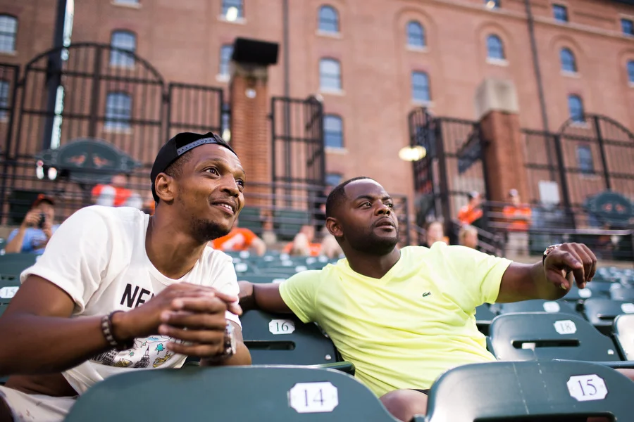 From left, Kevin and Mike watch the game in the bleachers. 