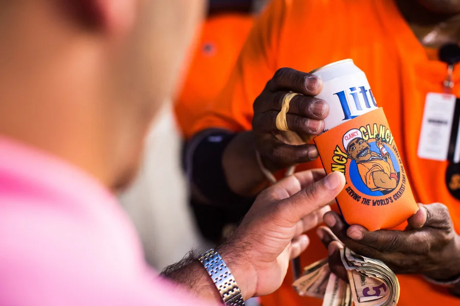 Clarence “Fancy Clancy” Haskett gives a fan a free coozie. He has been vending for 40 years. "After 40 years you done got close with a lot of people," he said. "And it's not just here at the ballpark." Over the years he said he's been to Oriole fans' weddings.