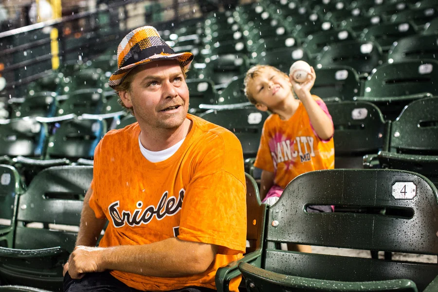 John Turpin and his four-year-old son Dylan sit in the bleachers during the rain delay. 