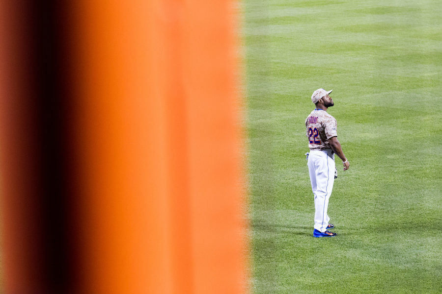 The Mets are the only team in baseball to have foul poles that aren't yellow. Here, Eric Young Jr. looks out before the start of an inning. 