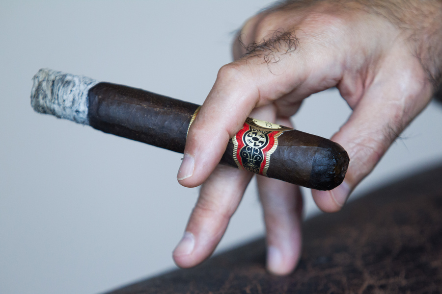 Dave Clarke holds his cigar at the Cuesta Rey Cigar Bar. 