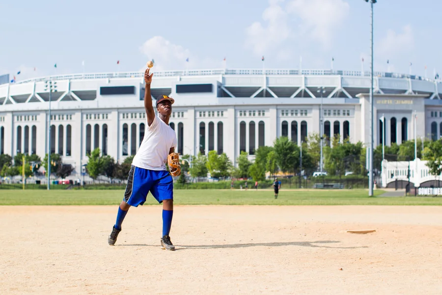 Tyler Clarke throws batting practice to Jamel (not pictured) on a field across the street from Yankee Stadium. Yostin and Elmer (not pictured) shagged batted balls in the outfield. 