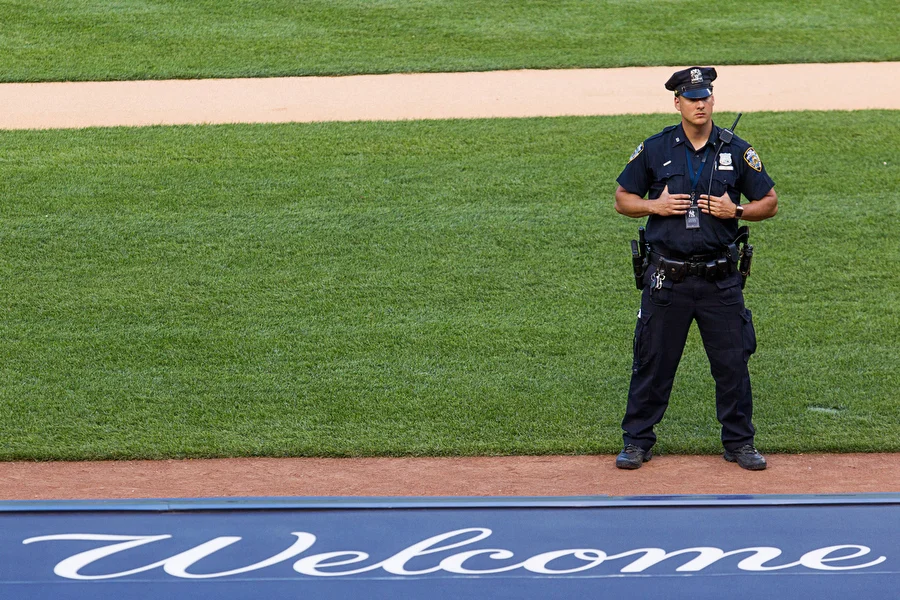 A policeman stands on the field before the game.