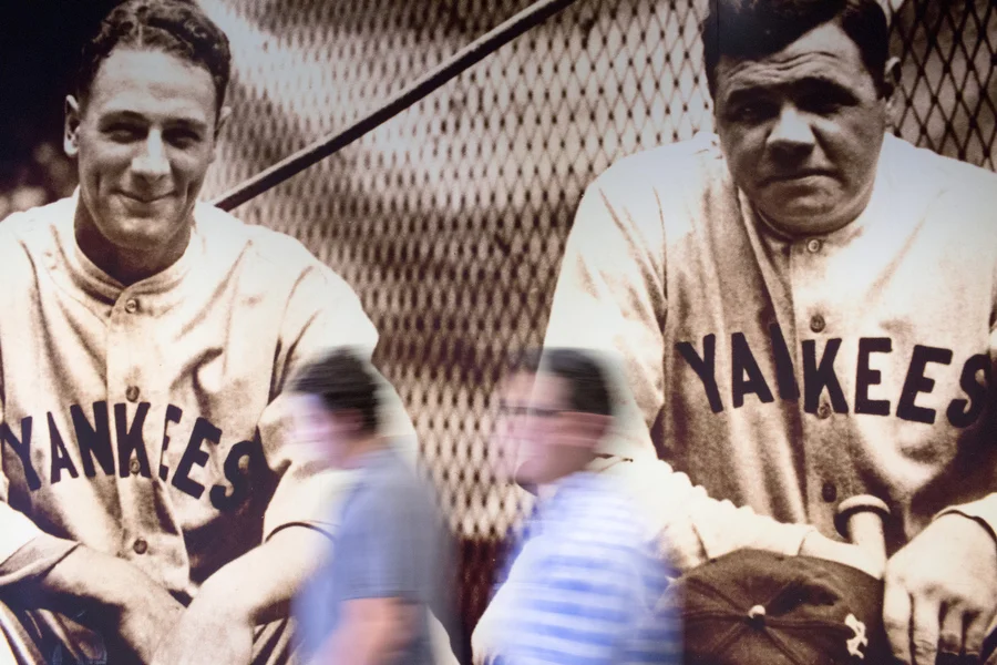 Fans walk past a photo of Babe Ruth and Lou Gehrig.