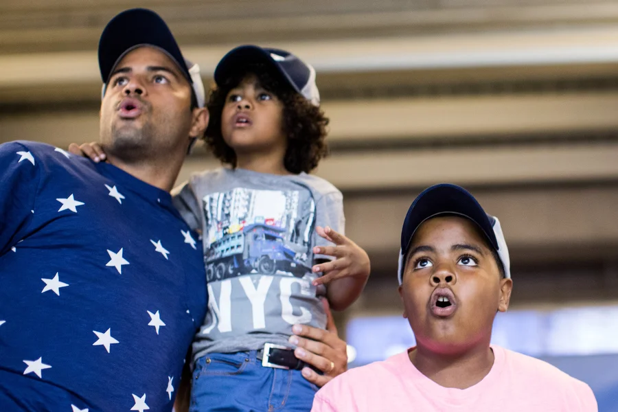 From left, Diego, his son Diego Andres and nephew Albert watch the trajectory of a Rangers player's home run. Diego and Diego Andres live in the Dominican Republic and had never before attended an MLB game. 