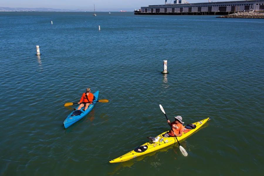 McCovey Cove Dave, left, has corralled 22 of the home runs hit into McCovey Cove. He's paddled out to almost all home games since 2005. Another home run-seeking kayaker on his right brings bread for seagulls and they sit on his kayak. 