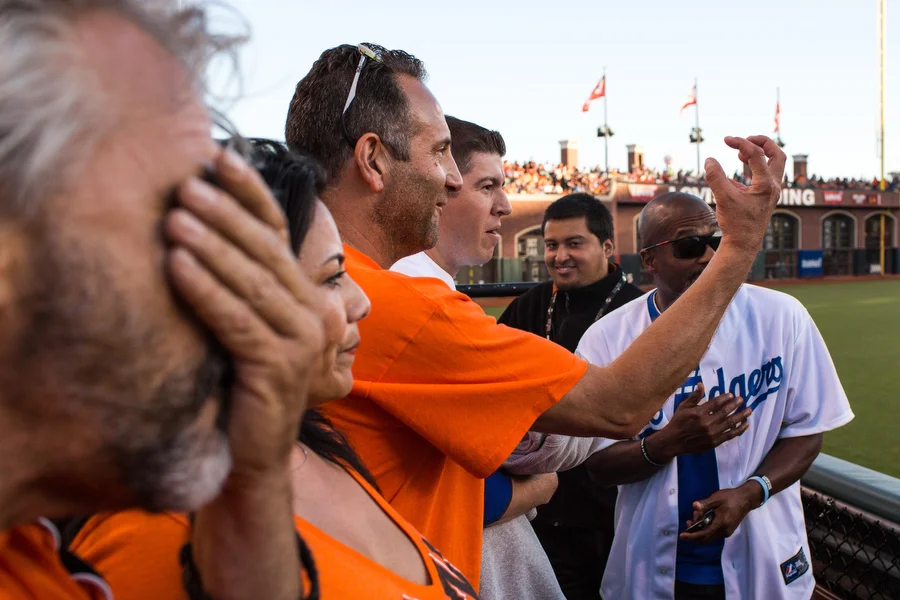 A fan, center in orange, reenacts a recent play in which a fan interfered with a ball hit by Yasiel Puig.