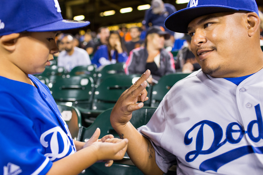 Rumaldo shows his son, Rumaldo Jr., how many more outs the Dodgers needed to secure the win. 