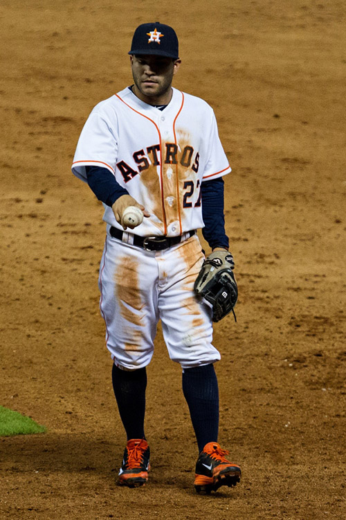 Astros second baseman Jose Altuve holds a ball with a split finger grip as he walks off the field.