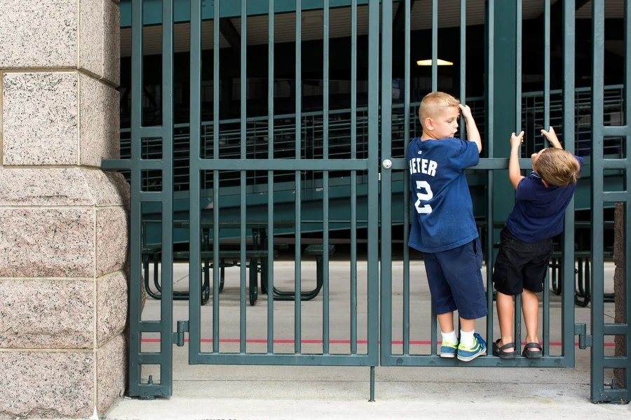 Marek Piekarski, left, and Jeter Mariano climb on a fence before entering the game. Marek's father said the name Marek comes from combining Yankees great Mickey Mantle's last name with Yankees great Derek Jeter's first name. 