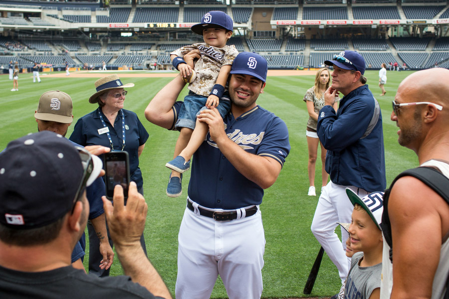 Outfielder Carlos Quentin puts a fan on his shoulder before the game. On select Sundays, the Padres invite fans to take pictures with the players. 