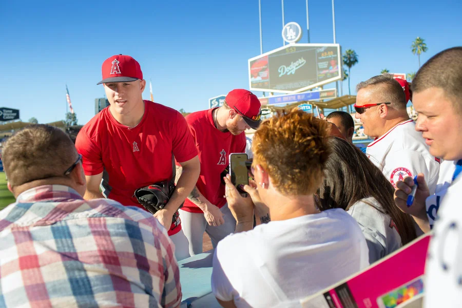 Angels outfielders Mike Trout, left, and Josh Hamilton, right, sign autographs. 