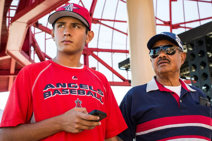 Roy, right, and his grandson Mathew wait outside the stadium before the game. Roy is an Angels fan and Mathew is a Dodgers fan. They say they don't let their competing team affiliations affect their relationship, however. 
