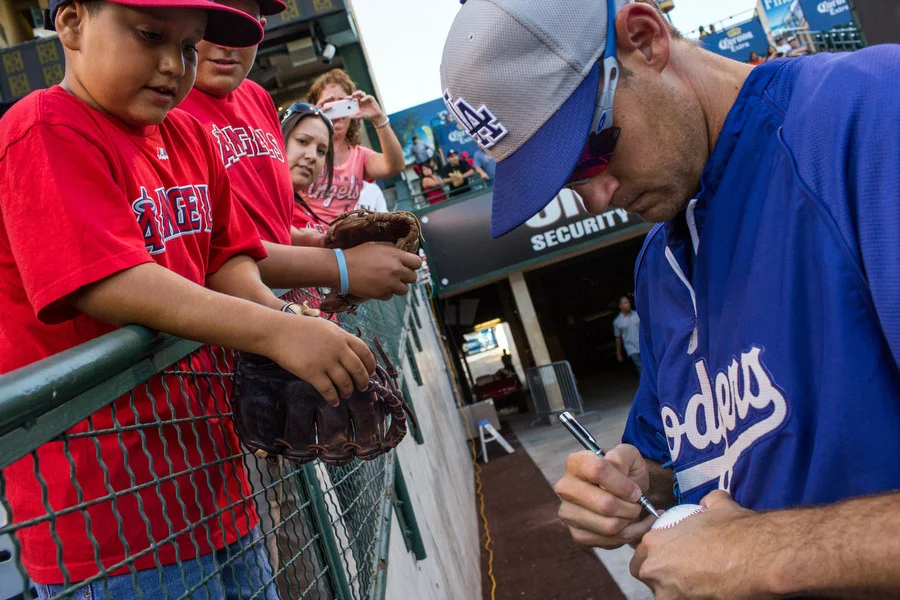 Dodgers pitcher Kevin Correia signs an autograph. 
