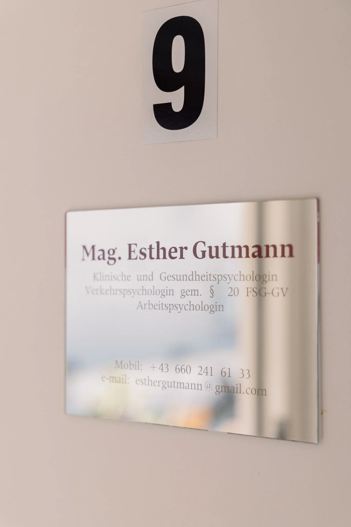 Büro- oder Praxisbeschilderung mit Namen Mag. Esther Gutmann, Kontaktinformationen, und Nummer 9 an der Wand befestigt.