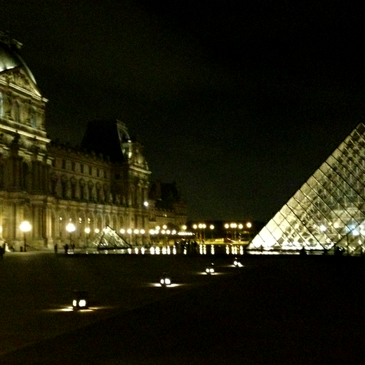 I.M. Pei's pyramid in the courtyard at the Louvre lit up at night makes for good bike riding, my favorite thing to do .