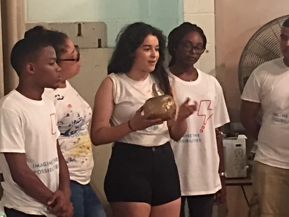 Kat Benscome, holding a golden apple from Greek mythology, encourages the JLL Volunteers to develop their creativity.
