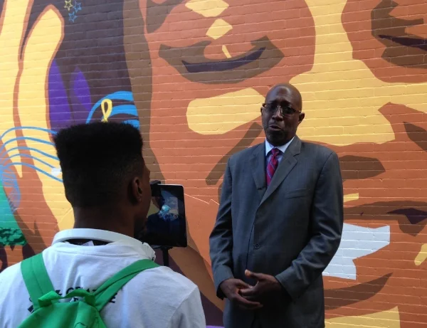 Youth Apprentices from the Multimedia Team interview Executive Director Donald Notice of West Harlem Group Assistance, at the unveiling of the 2015 mural, Harlem Melody .