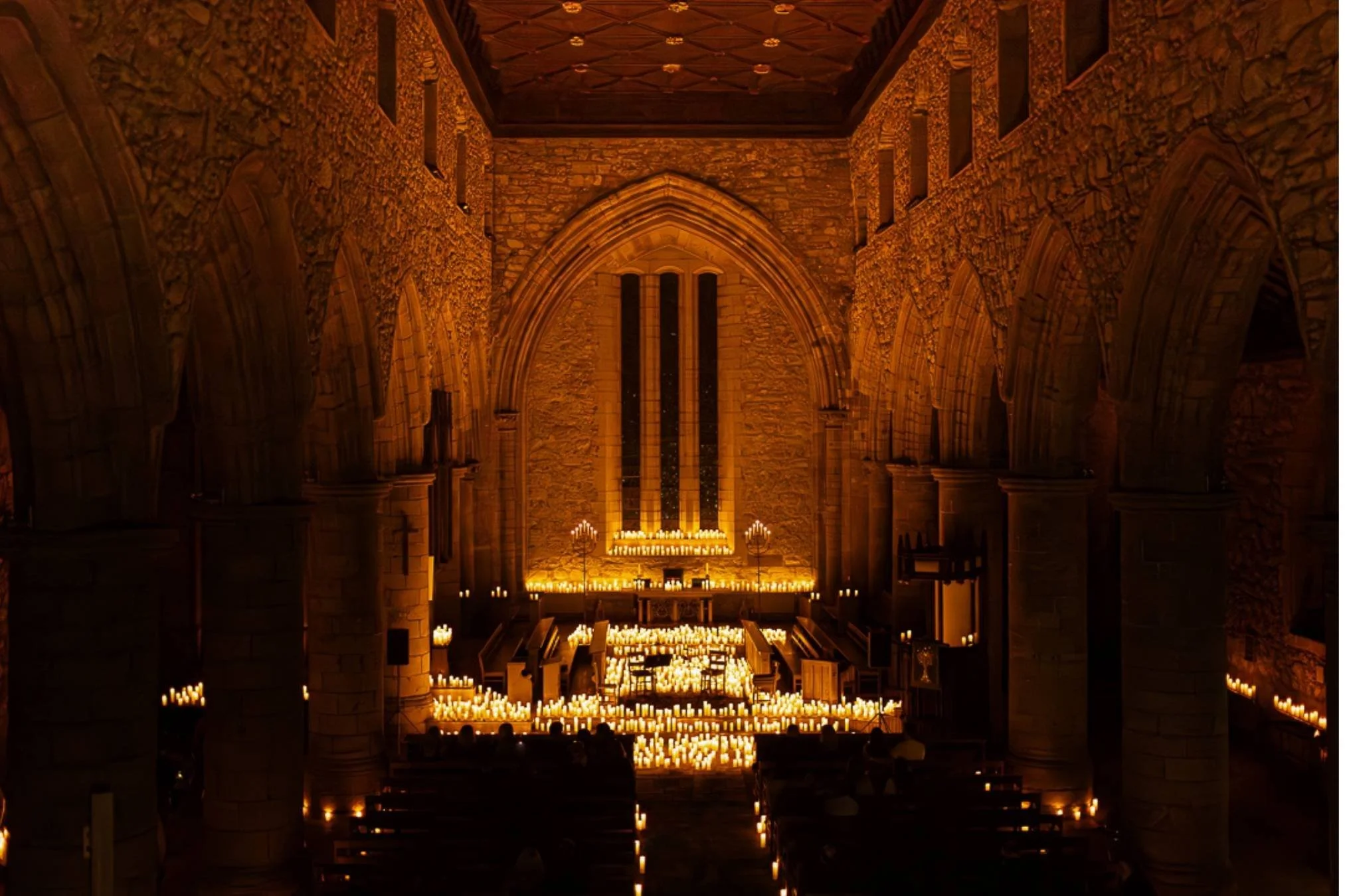 Old church illuminated by candlelight at night, creating a warm, atmospheric scene against the darkness.