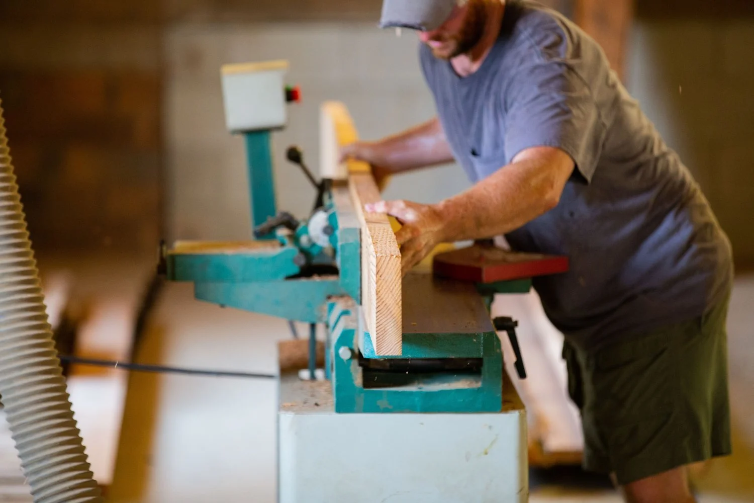 Carolina Farmstead craftsman milling a solid wood board in the workshop