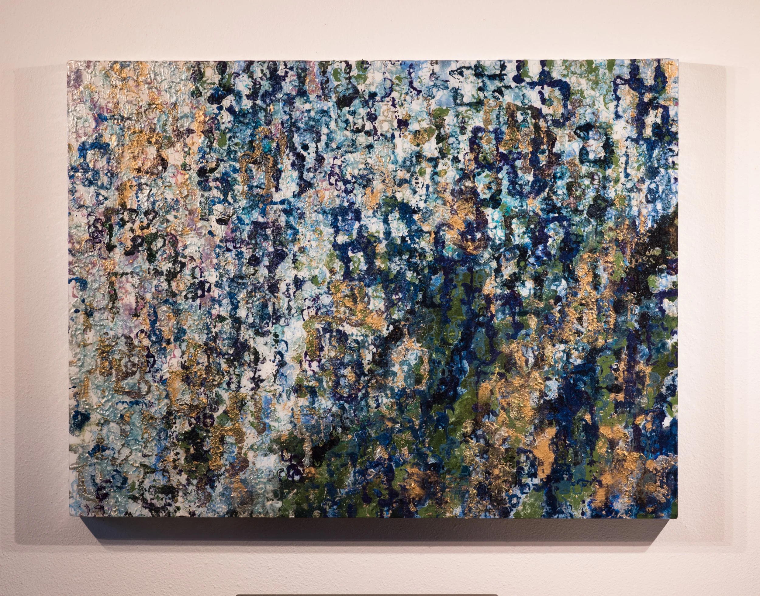 Abstract painting with a mix of blues, greens, black, white, gold, and tan colors, featuring textured and layered brushstrokes.