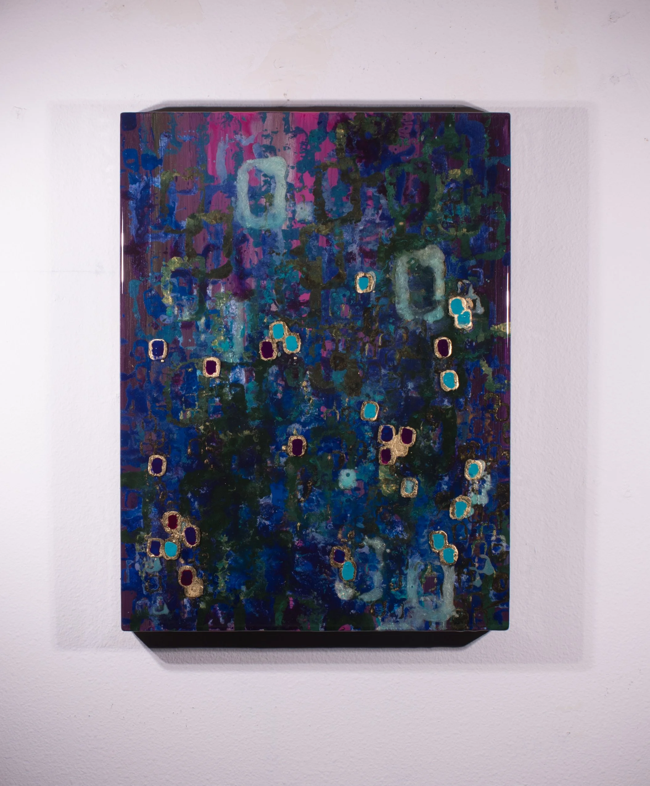 Abstract colorful painting with blue, purple, green, and gold accents displayed on a white wall.