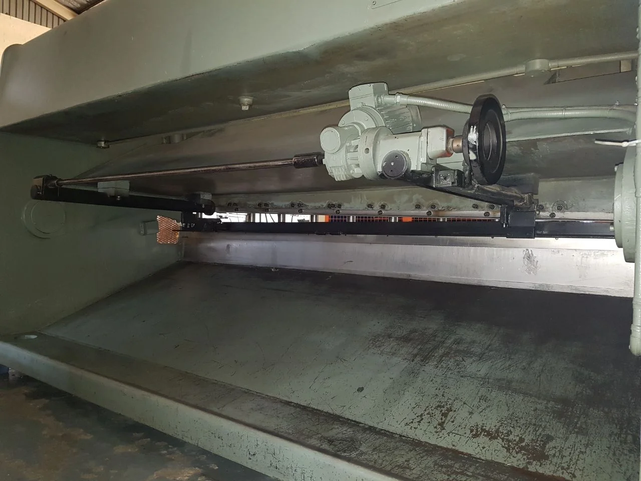 Rear of a swing beam guillotine. Note fulcrum on left side and back gauge layout.