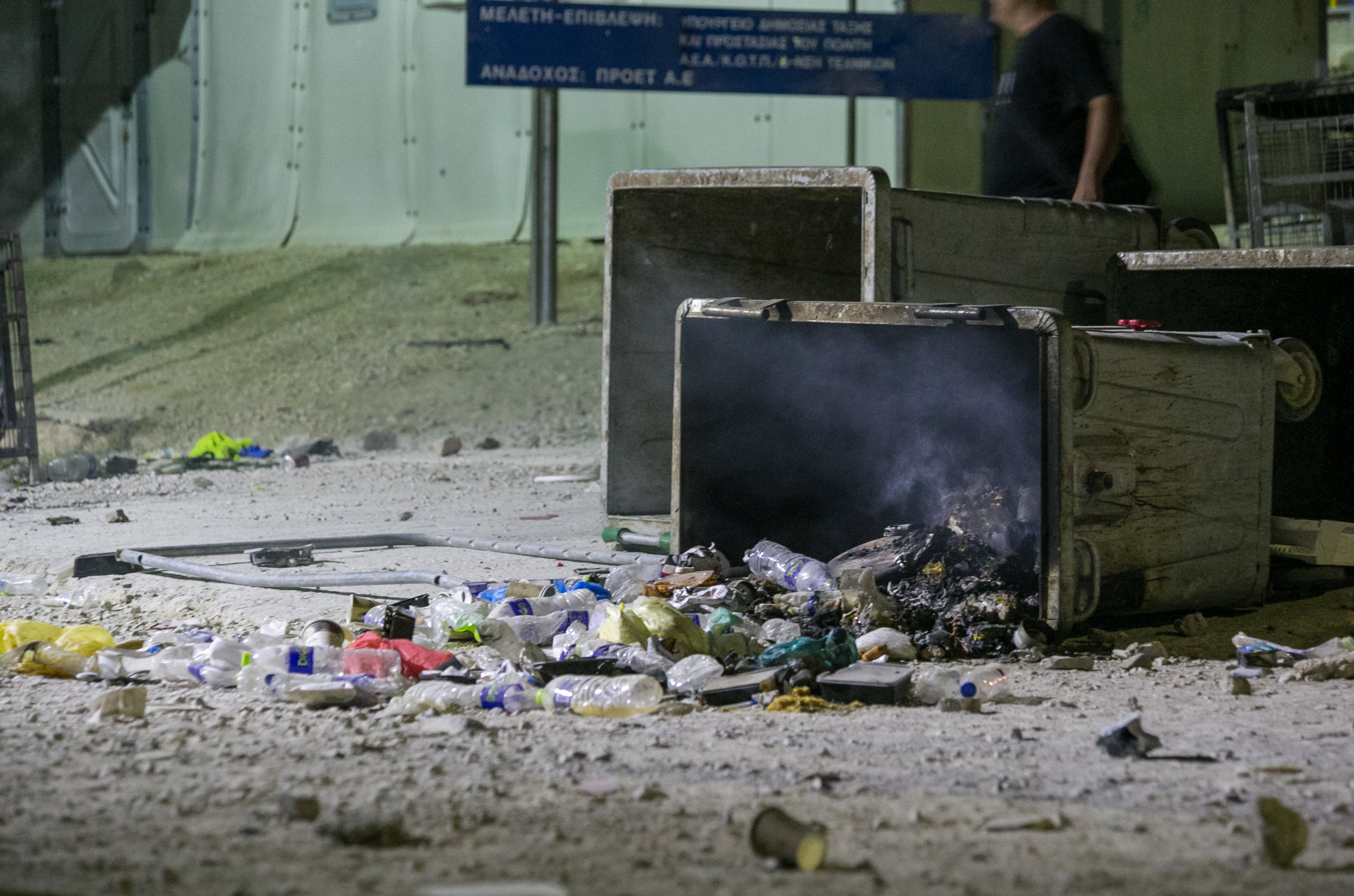 Smoldering trash spills out of a dumpster during a riot at the Moria Refugee Camp 