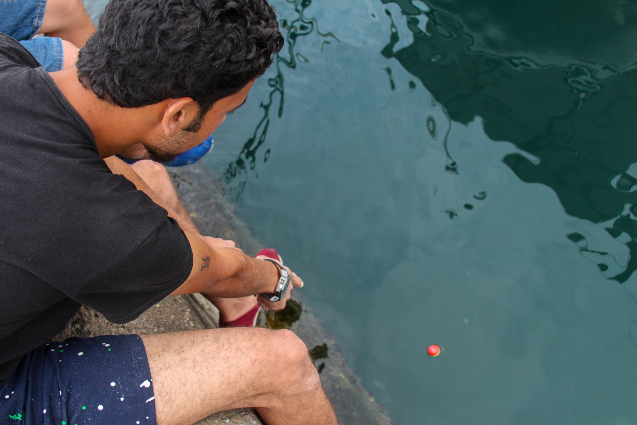  A Syrian migrant fishes off the dock in the port of Mytiline 