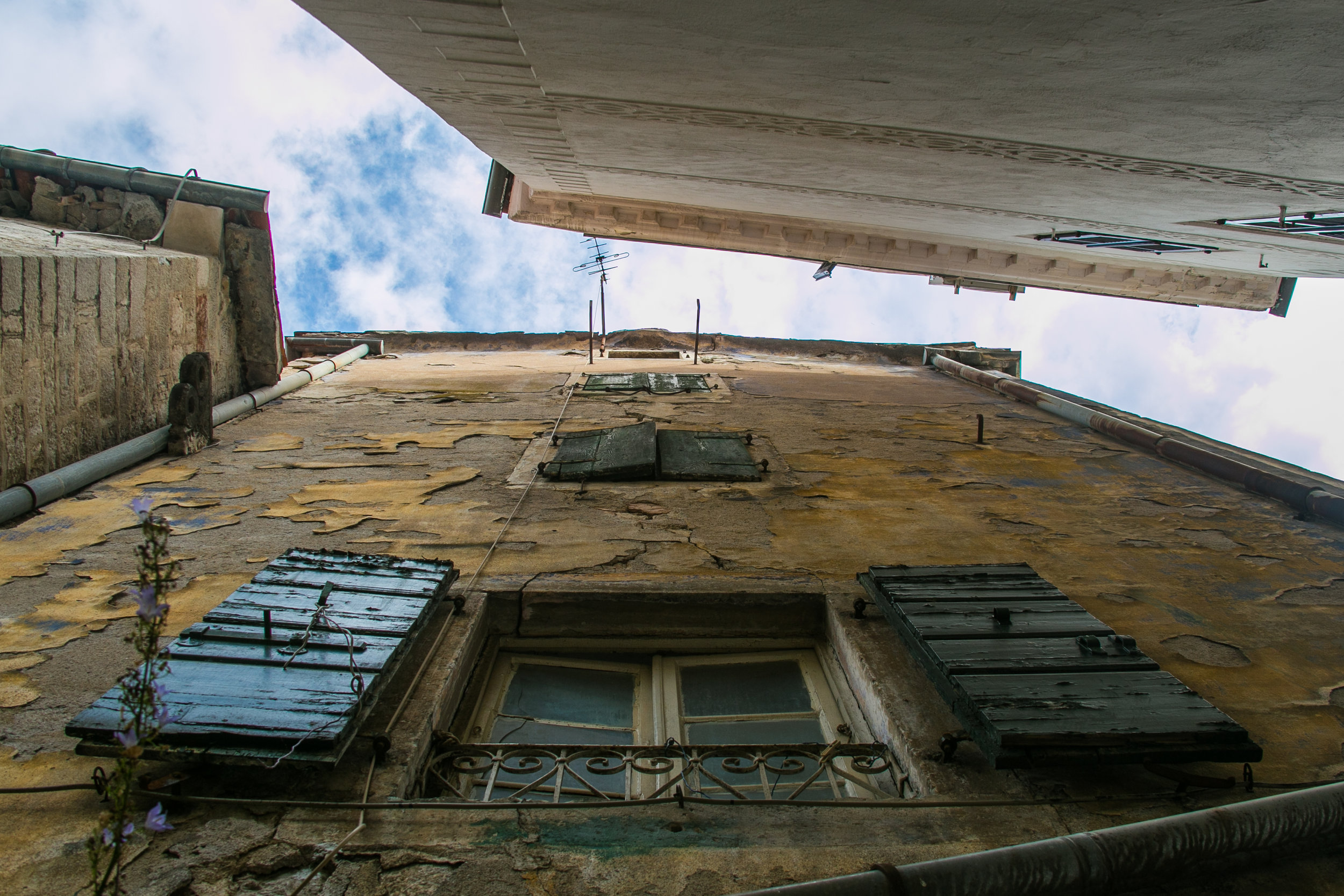  Standing between large stone houses located in the Old City of Kotor, Montenegro.&nbsp; 