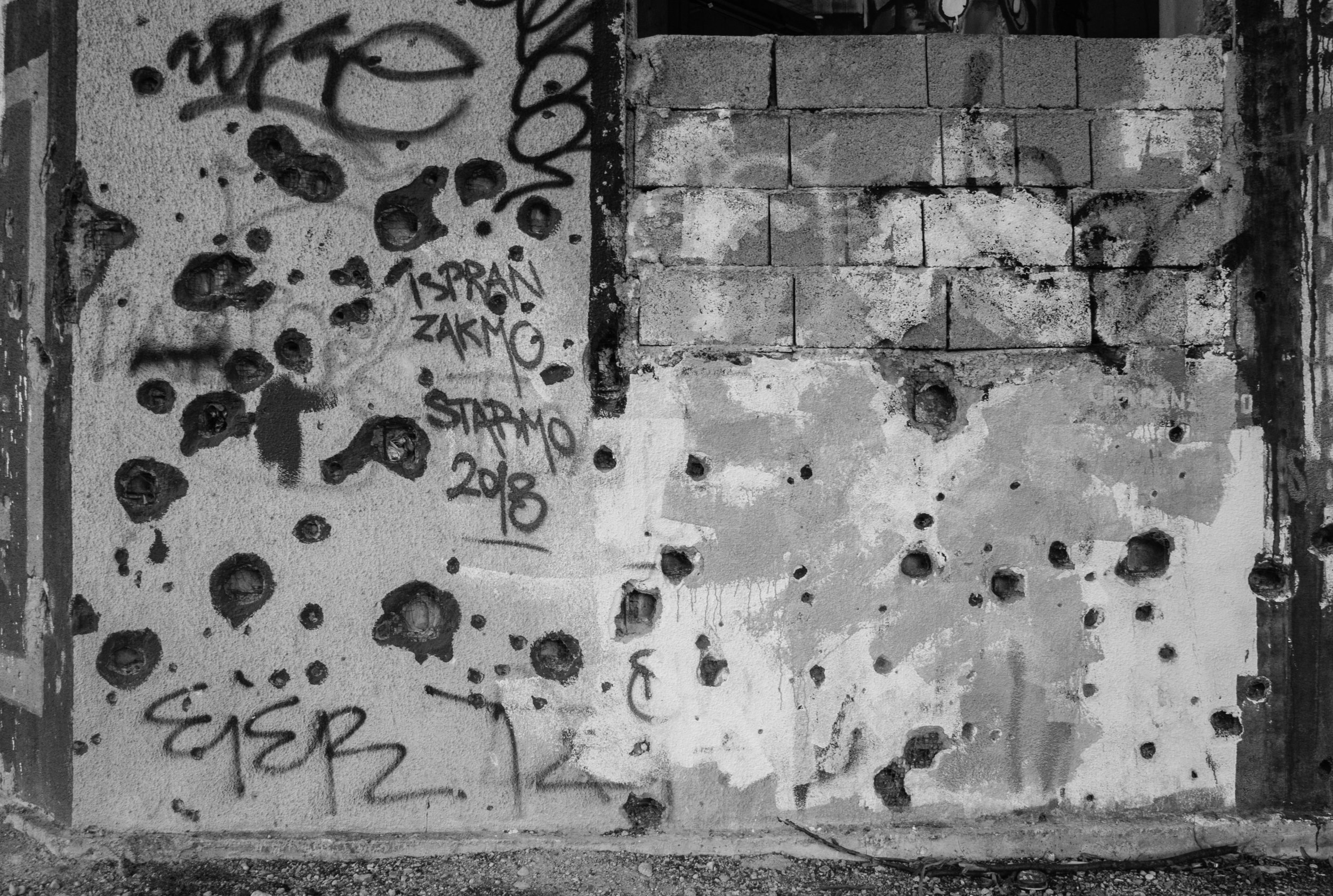  Bullet holes riddle the side of an apartment building in Mostar, Bosnia. The city served as a battle front between Croatian and Republic of Bosnia forces (just one of many racial battles) during the much larger Bosnian War. The two sides battled for