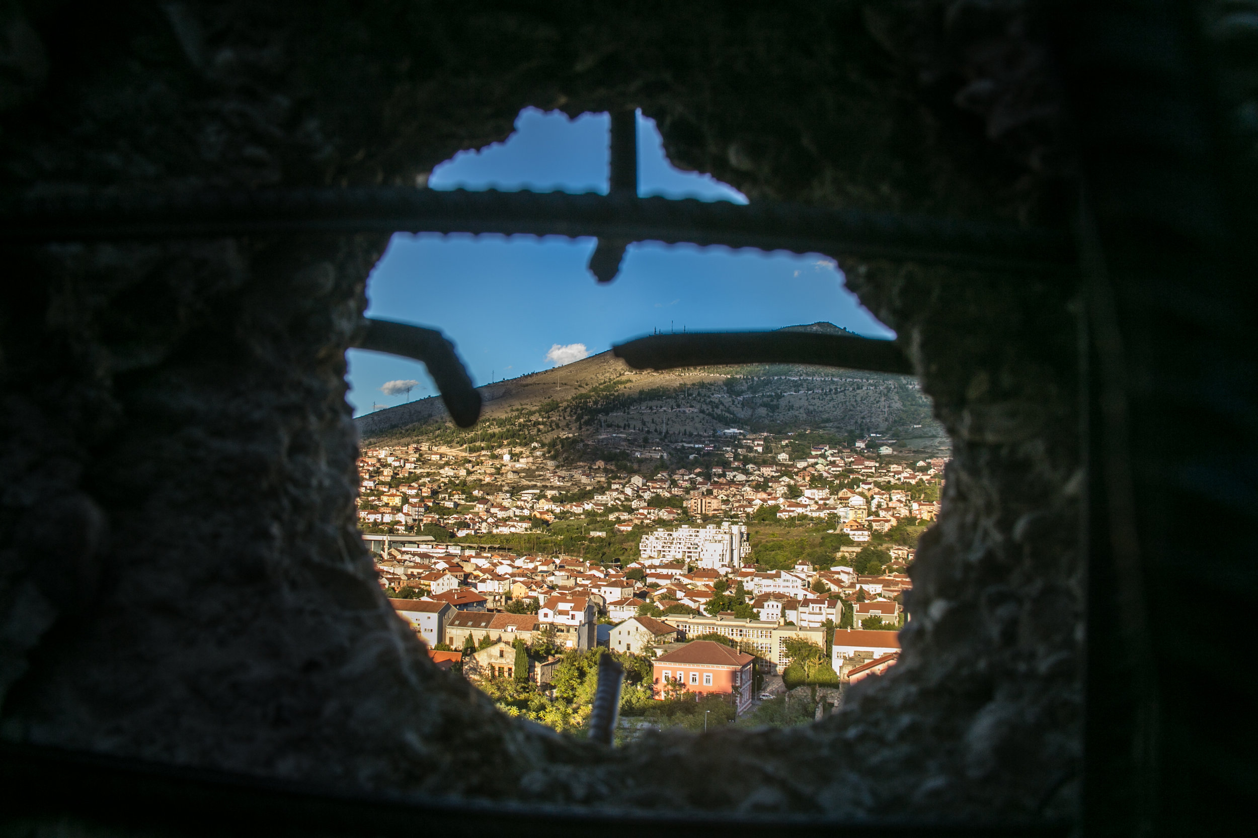  A sniper hole punched in the wall of an old bank building looks over the neighborhoods of Mostar, Bosnia. The bank was repurposed during the Bosnian War in an attempt to help defend the city from attacking Croatians.&nbsp; 