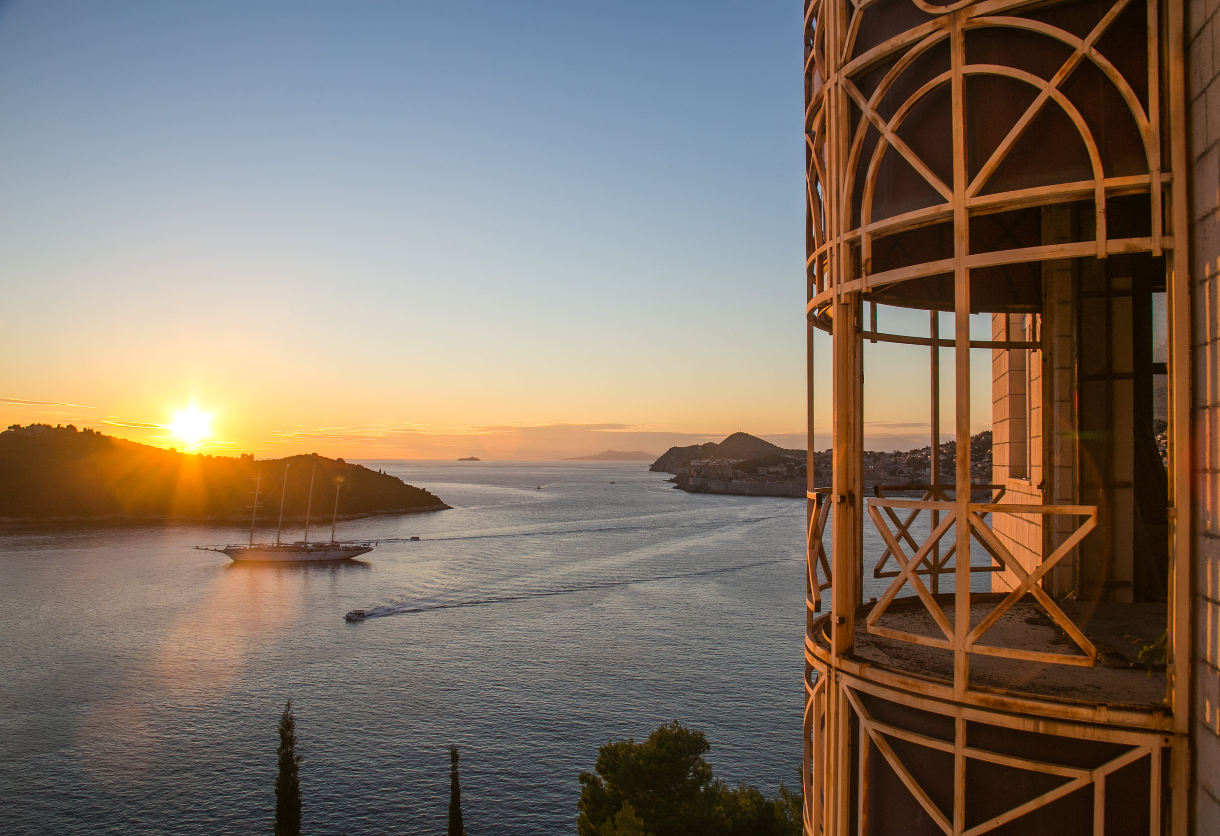  The sun sets over anchored sailboats in the bay of Dubrovnik. Photographed from the blown-out windows of the Belvedere Hotel in Dubrovnik,&nbsp;Croatia. The five-star hotel was opened in 1986, only to be closed 6 years later due to bombing damages d