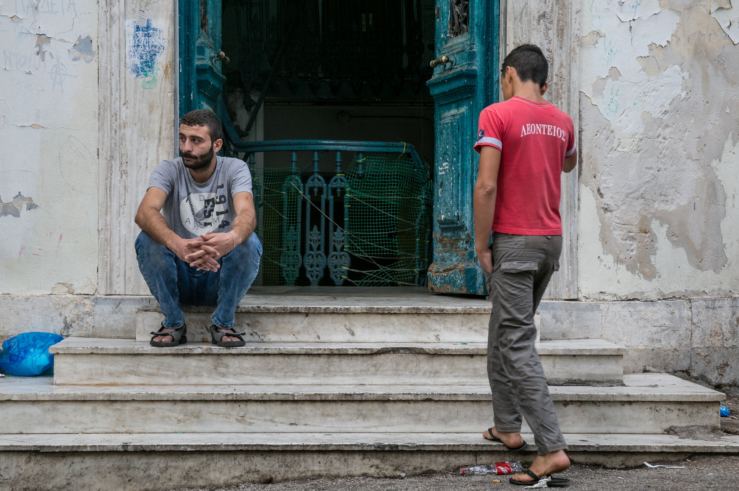  10/17/16 - Men sit outside the entrance to Jasmine School. 