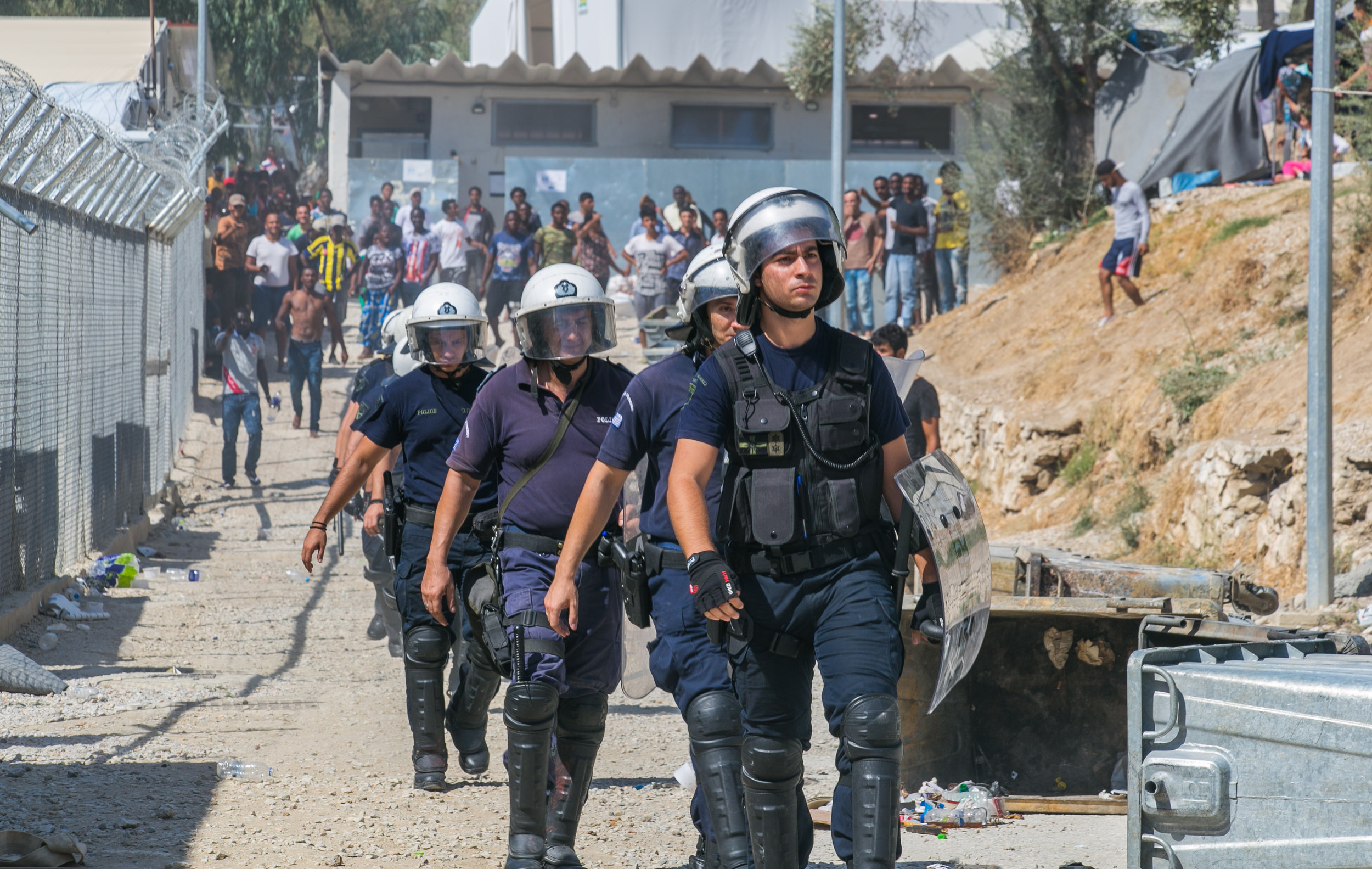  09/19/16 - 2:30pm: Greek riot police return to their compound as a crowd of migrants gathered to chant and throw rocks. 